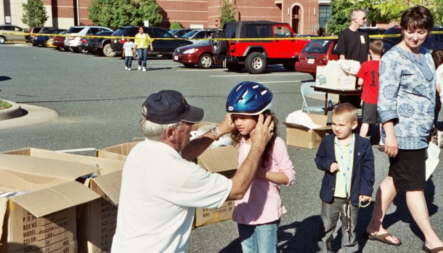 Save Your Heart for Love May 2009
Mike Schaefer  fits a bike helmet on a child